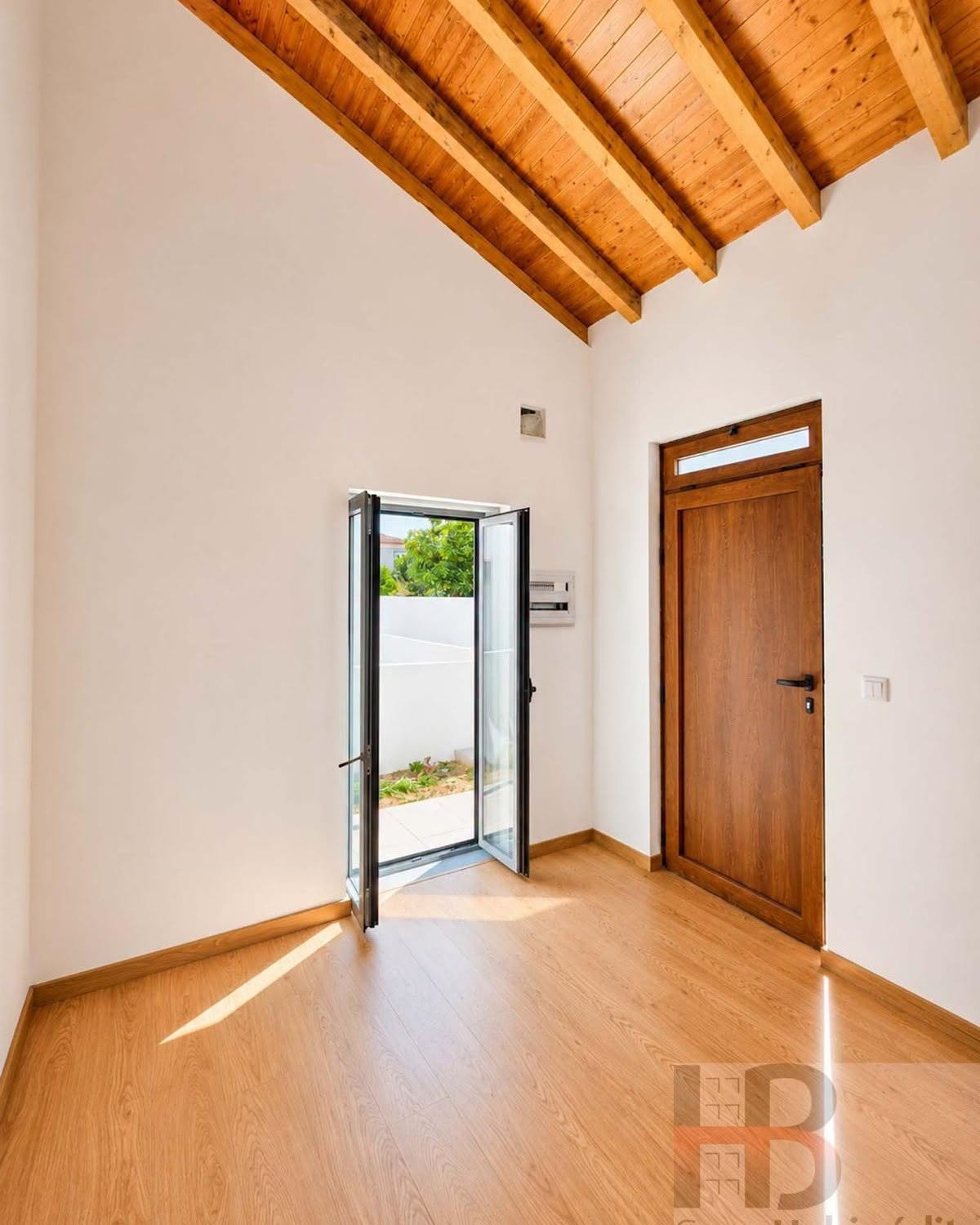 Interior com teto em madeira e acesso ao exterior
